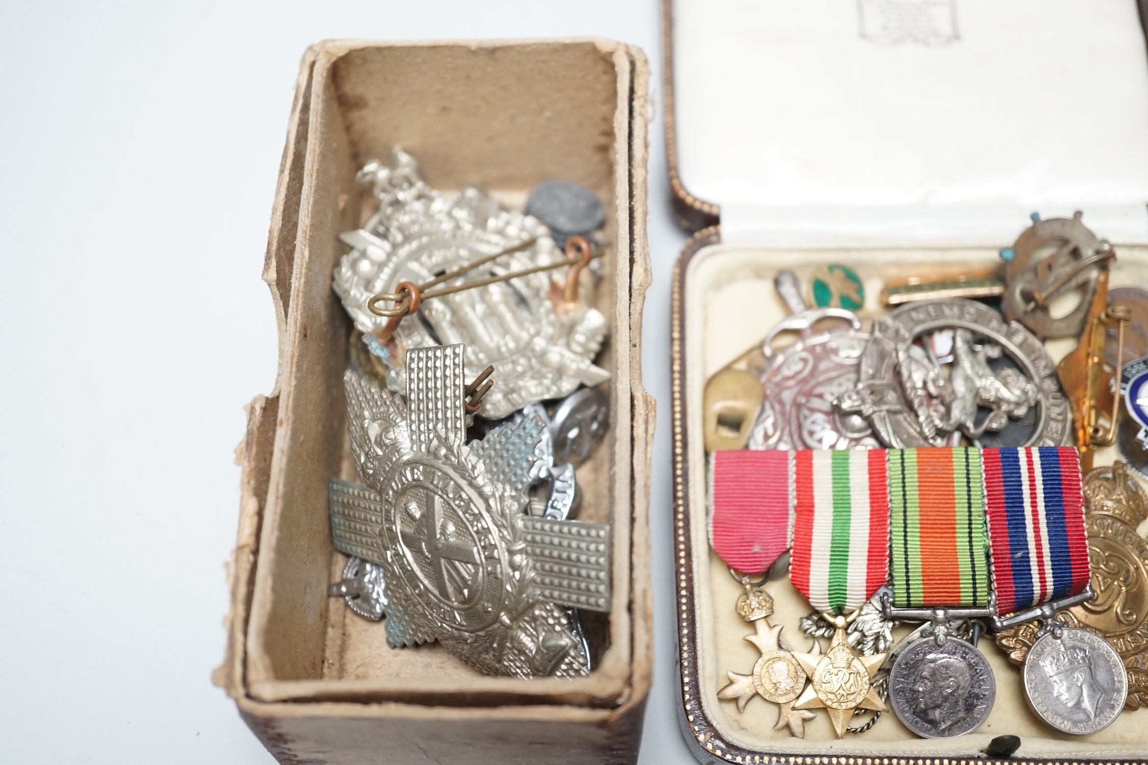 Two powder flasks and militaria including cap badges and miniature medals